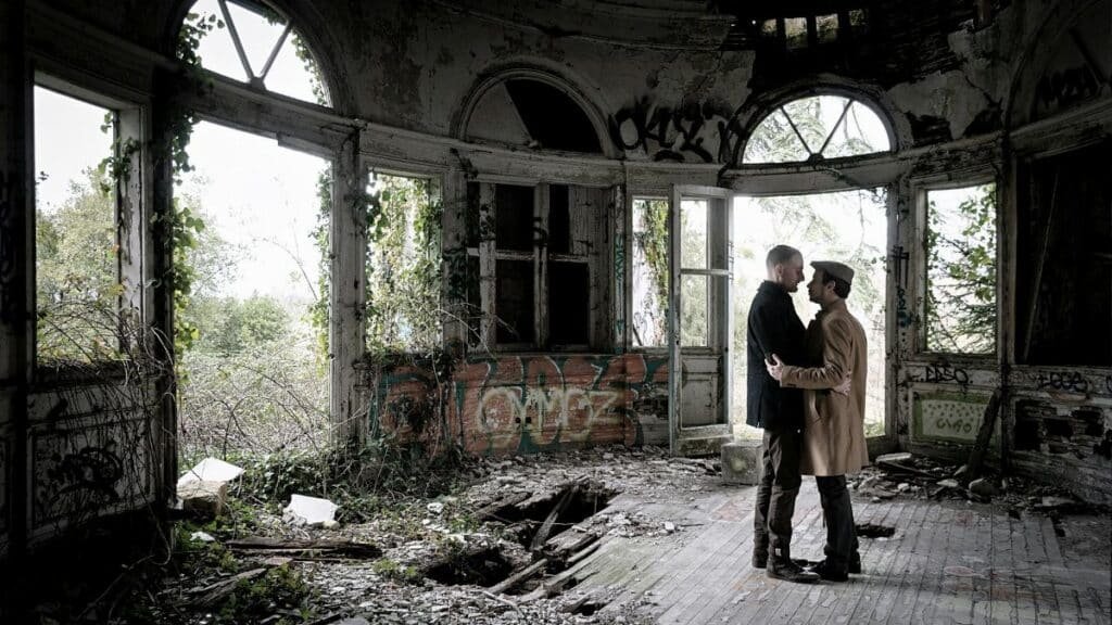 Couple shares a tender moment in a decaying, graffiti-covered room in Bordeaux.