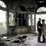 Couple shares a tender moment in a decaying, graffiti-covered room in Bordeaux.