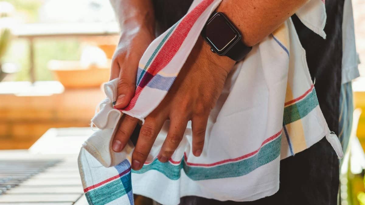 A detailed view of a person drying their hands with a colorful towel indoors, highlighting everyday hygiene.