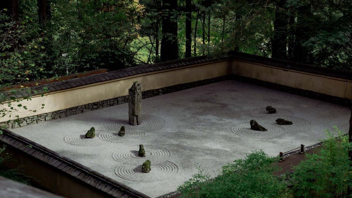 A serene zen rock garden in Portland surrounded by lush greenery, ideal for mindfulness.
