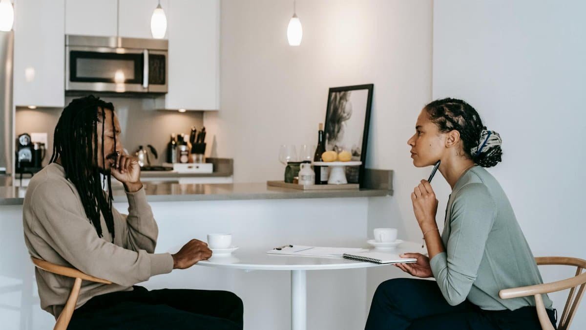 A focused therapy session between a consultant and client discussing mental health indoors.