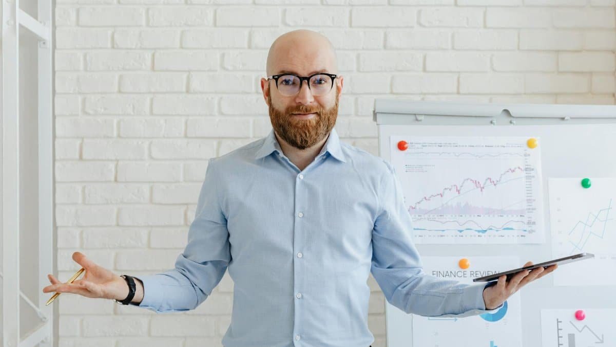 A businessman in an office with charts presenting financial analysis confidently.
