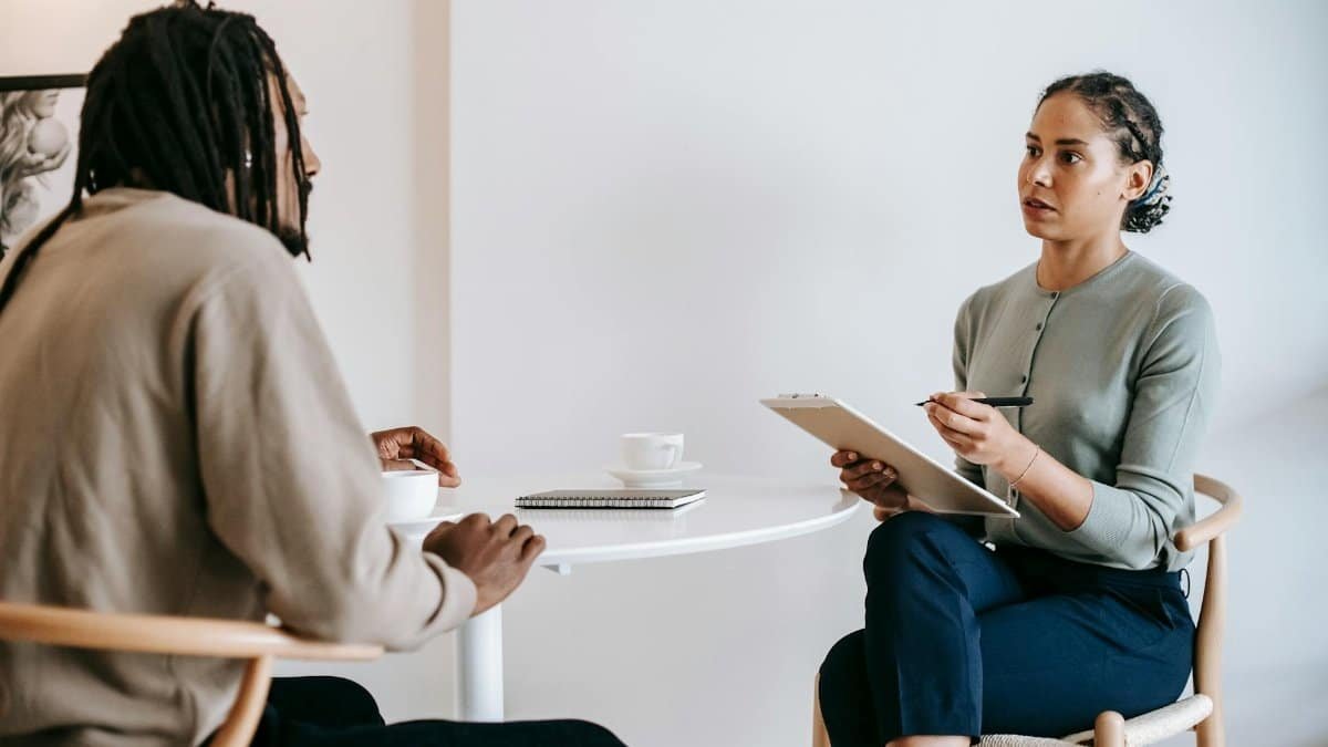 A professional job interview between a man and woman in a modern office setting.