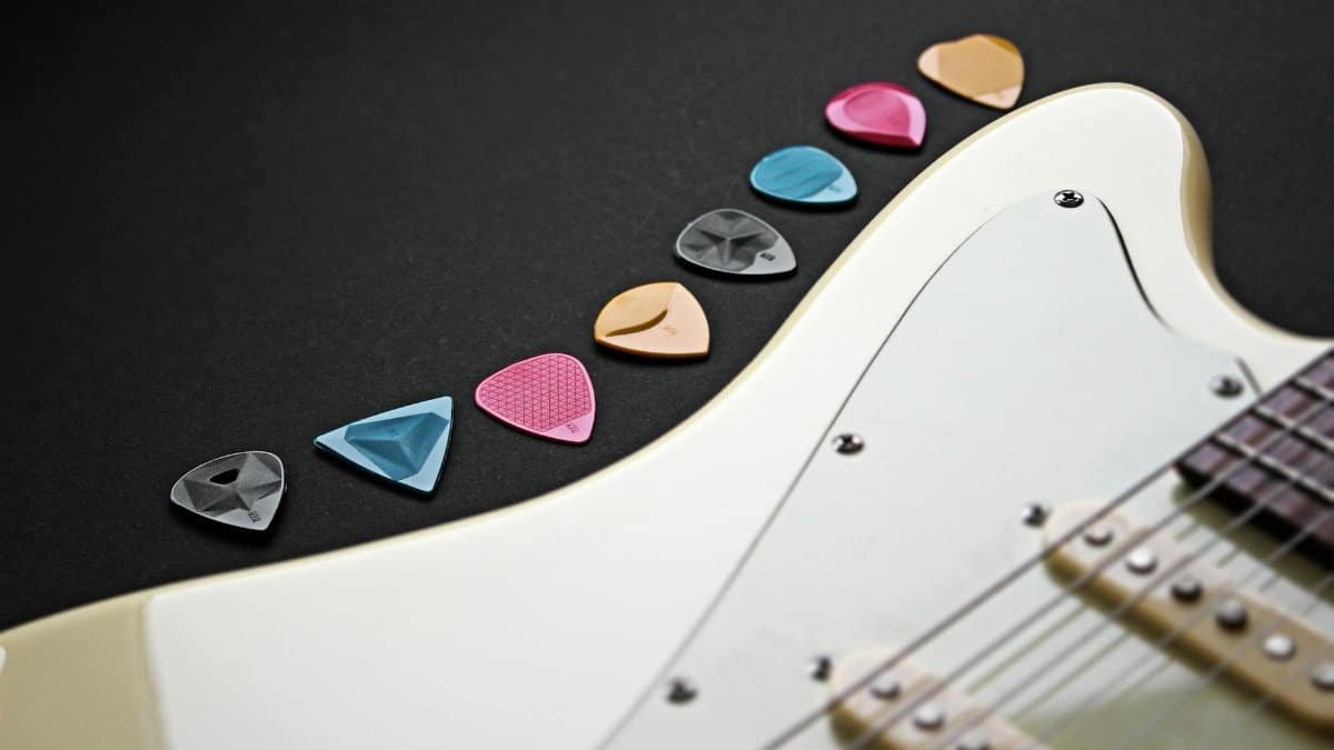 Close-up of colorful guitar picks on an electric guitar.