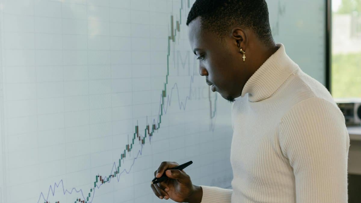 Young male strategist analyzing financial growth trends on a digital screen.