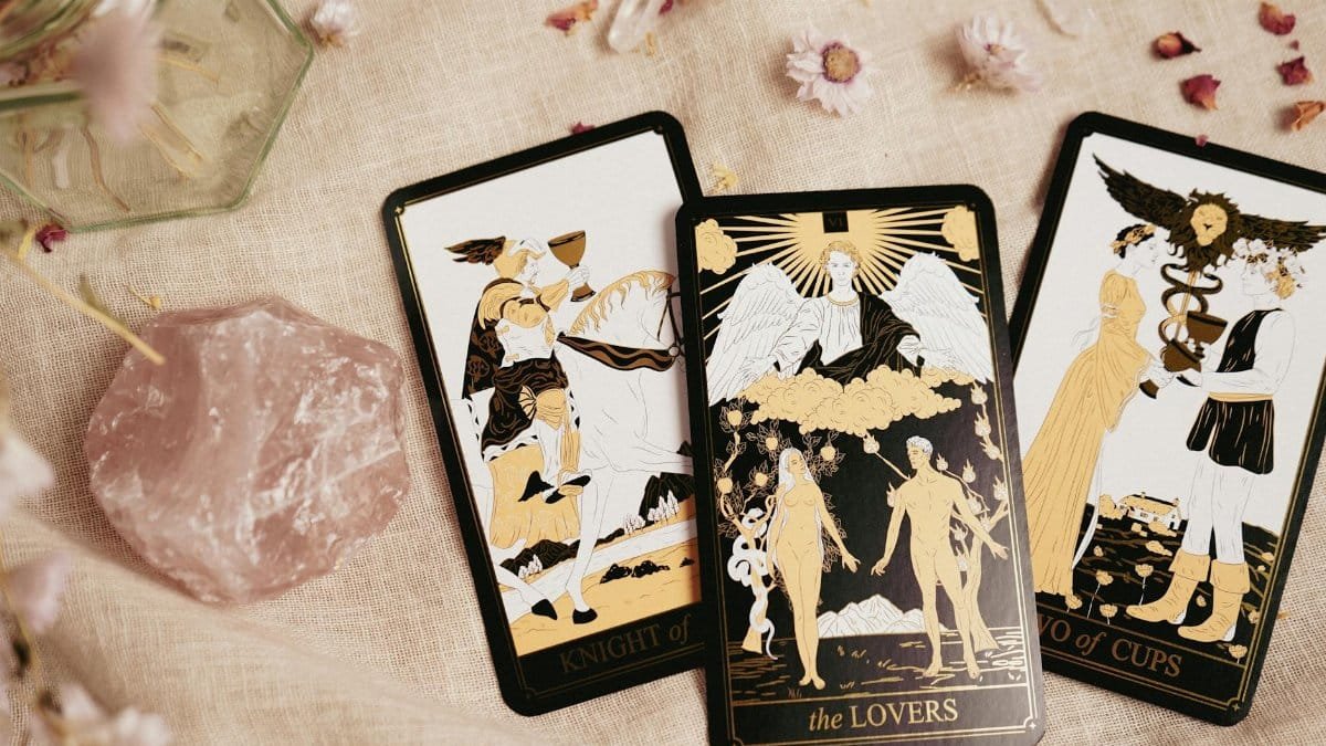 Stylish tarot cards with a rose quartz crystal on a textured background, ideal for divination themes.