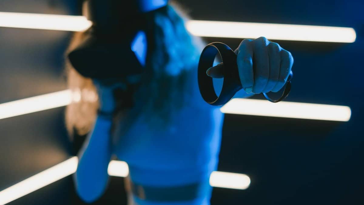 A woman is immersed in virtual reality gaming, holding a VR controller in one hand.