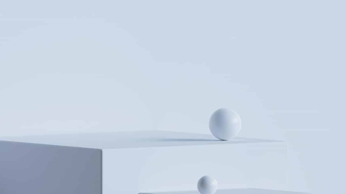 Elegant minimalist scene with white geometric shapes on a light blue backdrop.