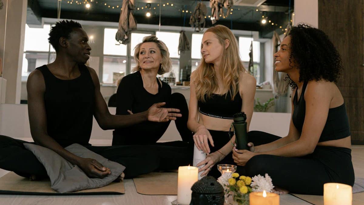 A diverse group of adults engaged in relaxation and meditation in a cozy yoga studio setting.