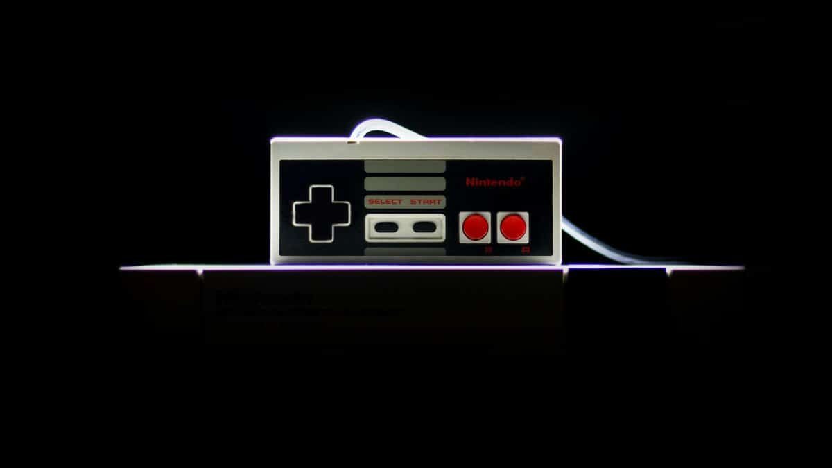 A close-up of a classic NES controller with dramatic lighting on a black background, evoking nostalgia.