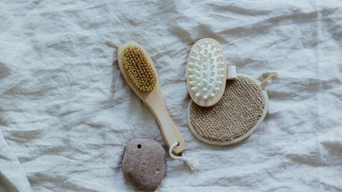 Flat lay of natural spa tools on a textured fabric surface for a minimalist and calming aesthetic.