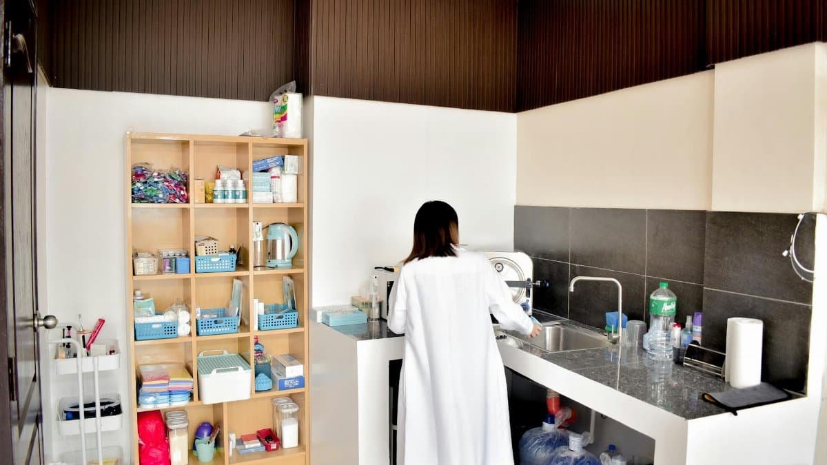 A female technician in a lab coat working in a well-organized laboratory setting.