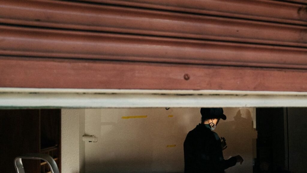 A silhouetted figure inside an open garage in Seattle, creating a mysterious ambiance.