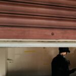A silhouetted figure inside an open garage in Seattle, creating a mysterious ambiance.