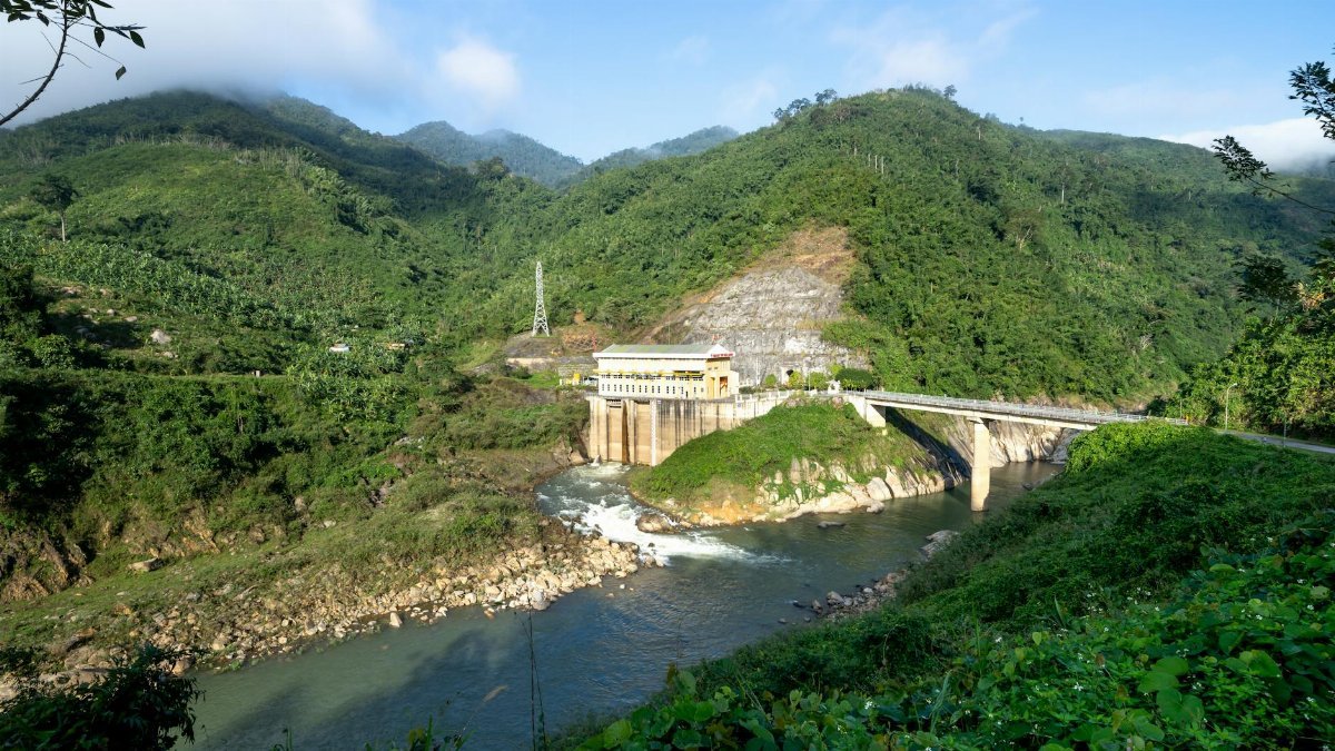A panoramic view of a hydroelectric dam blending with the verdant mountain scenery, showcasing sustainable energy.