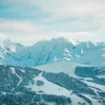 A serene winter landscape showcasing snow-covered mountains and forests in Megève, France.