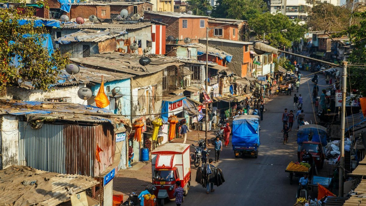 Street view in Mumbai showcasing daily life, bustling market, and colorful homes.