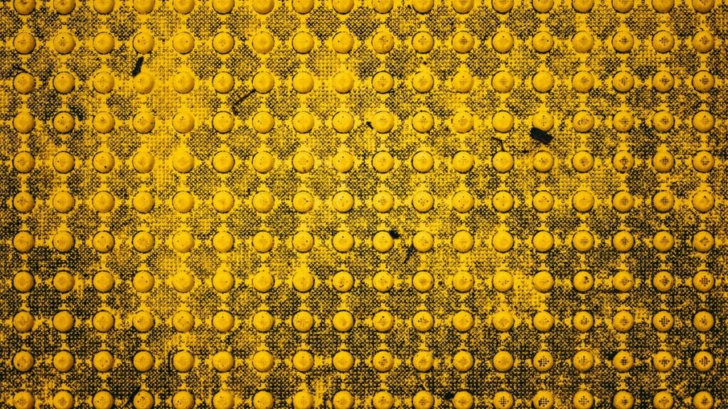 Close-up of a textured yellow tactile ground surface highlighting geometric patterns in Boise, Idaho.