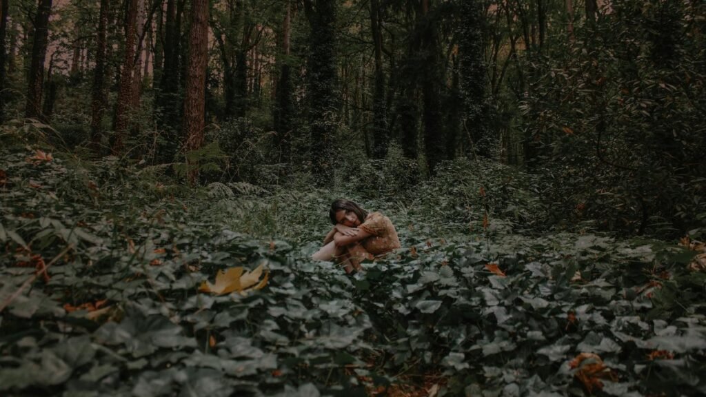 A calm moment captured with a woman sitting amidst lush greenery in a Portland forest.