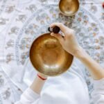 A top-down view of meditation using a Tibetan singing bowl for relaxation and healing.