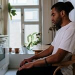 A thoughtful man sits quietly in the kitchen, reflecting and contemplating life indoors.