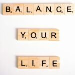 Inspirational message 'Balance Your Life' made with Scrabble tiles on a white background.