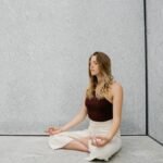 Young woman practicing yoga meditation indoors with calm expression and peaceful atmosphere.