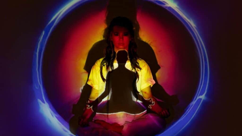 Woman meditating with vibrant aura and energy field.