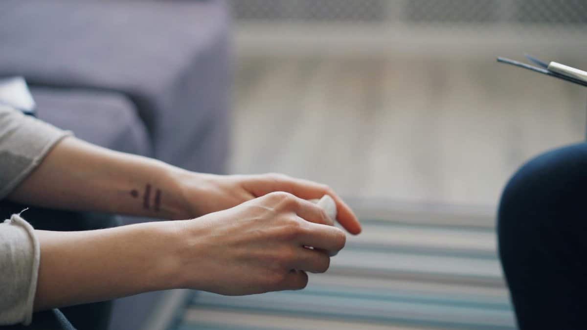 Close-up of hands during therapy session, symbolizing mental health support.