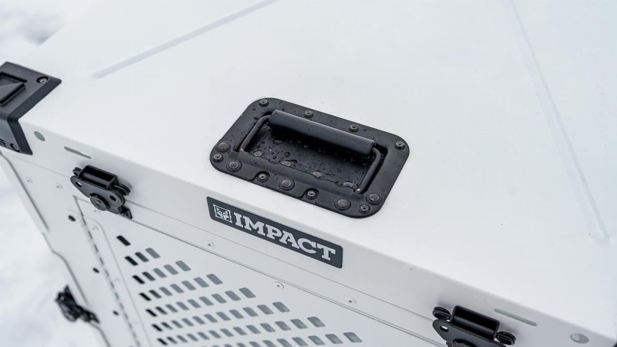 Durable Impact dog crate photographed in a snowy setting, showcasing quality design and waterproof capability.