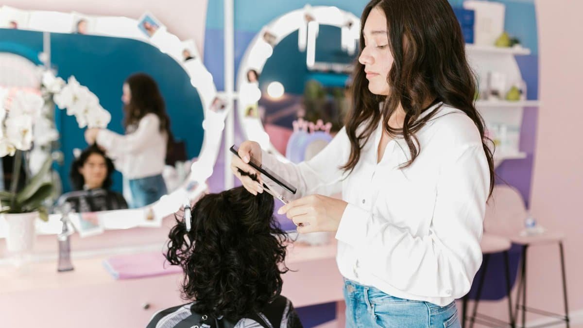 A hairdresser in a modern salon skillfully trims a woman's hair.