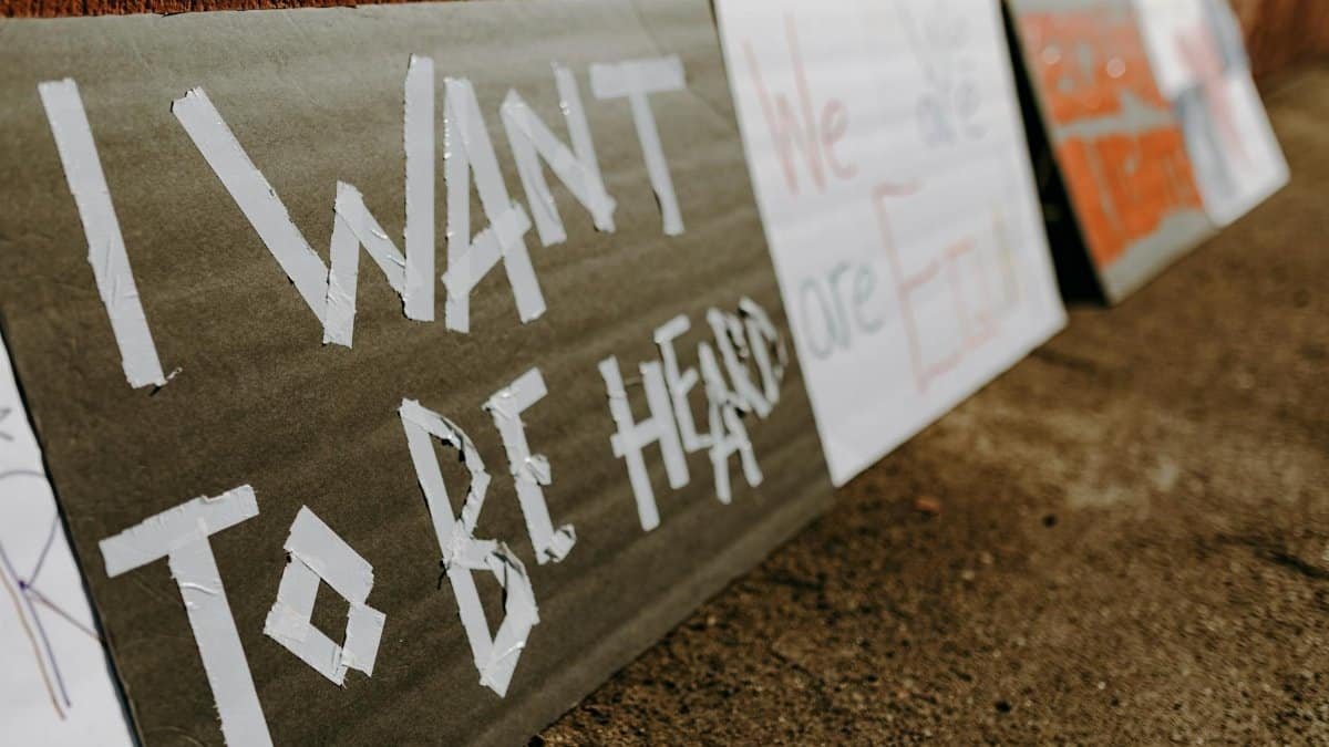 Close-up of protest signs calling for equality and justice placed on the ground.