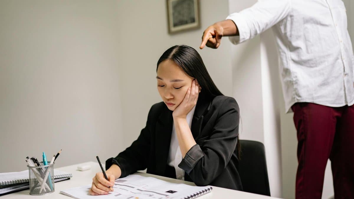 An unhappy employee experiencing workplace bullying, depicted by finger pointing in an office setting.