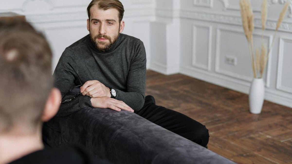 A professional therapist conducting a mental health consultation with a patient in a well-decorated indoor setting.