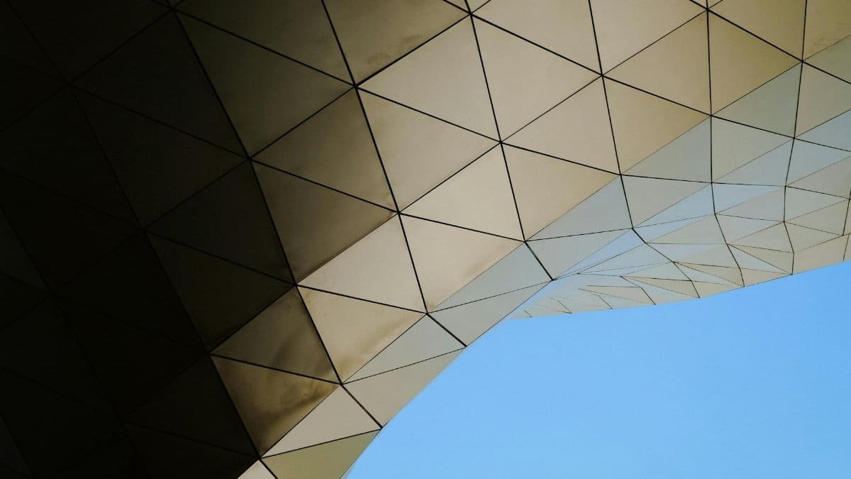 A striking view of modern architecture featuring a geometric pattern against a clear blue sky.