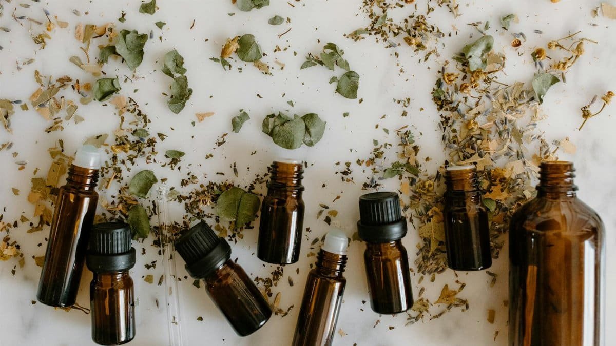 Flat lay of brown glass bottles and dried herbs, perfect for aromatherapy themes.