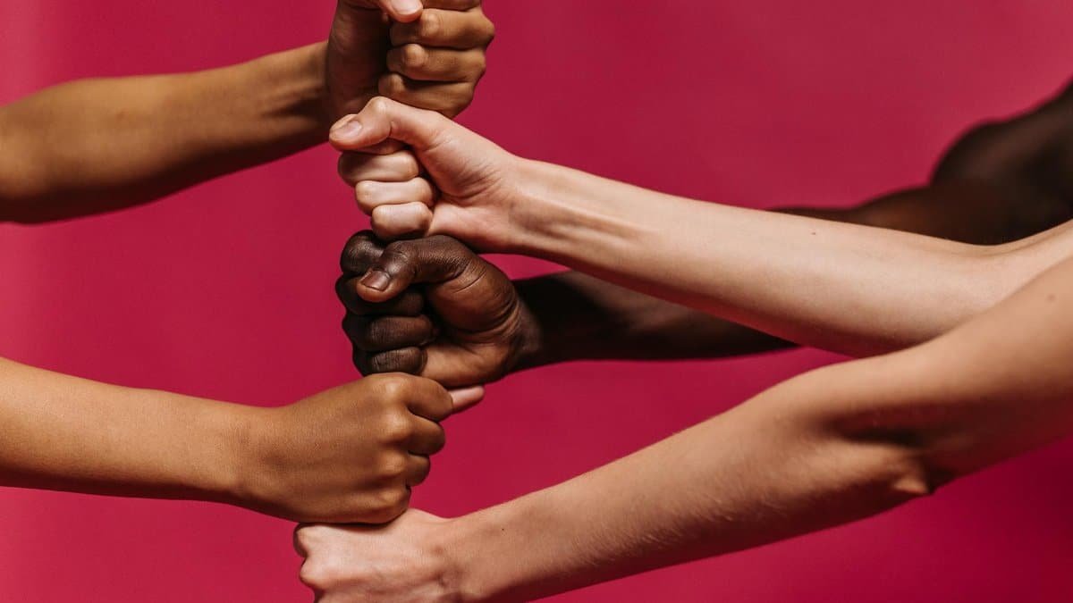 Close-up of diverse hands coming together symbolizing unity and strength.