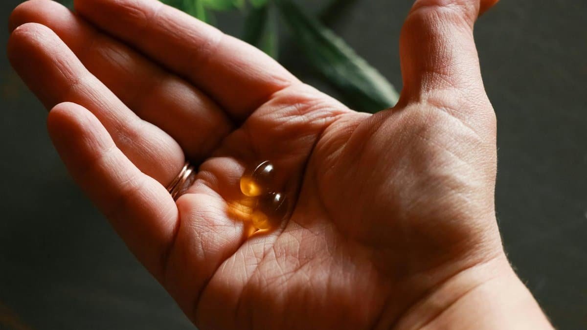 Close-up of a hand holding soft gel capsules, highlighting health and wellness.