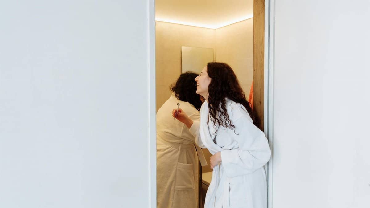 A loving couple enjoys an intimate morning routine in their bathroom, capturing a tender moment.