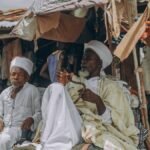 Candid photo of men in a traditional market, depicting cultural attire and daily life.