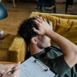 A man lying on a sofa during a therapy session, appearing distressed.