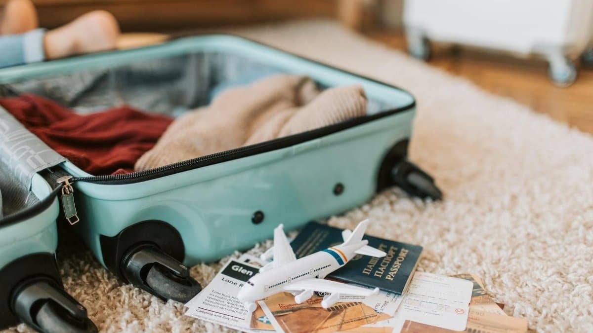 Close-up of an open suitcase with travel essentials like passport and tickets, ready for a journey.