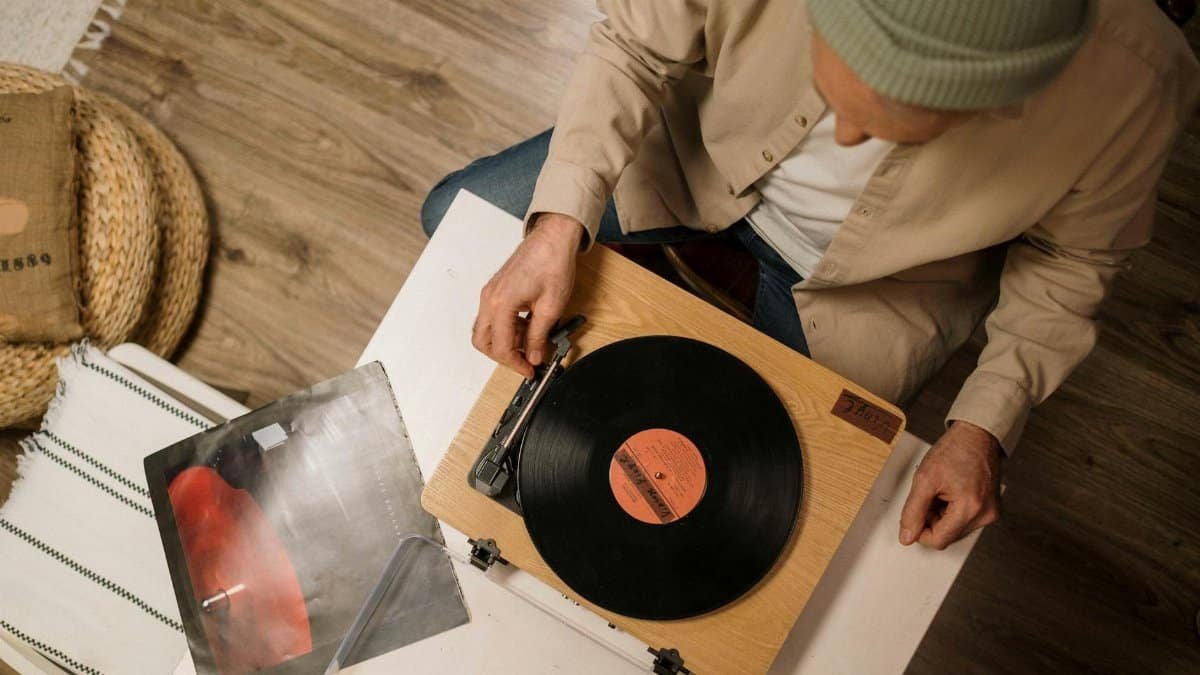 Top-down view of a person playing a vinyl record on a turntable indoors.