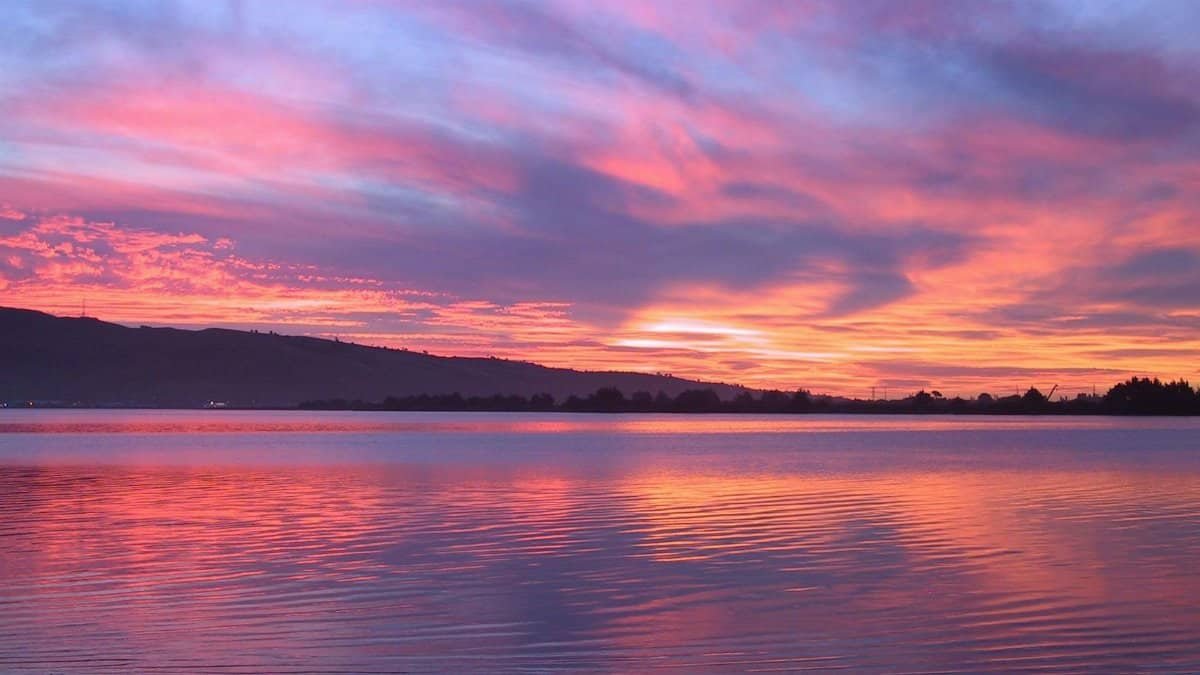 A stunning sunset over a serene lake with colorful sky reflections, ideal for nature themes.