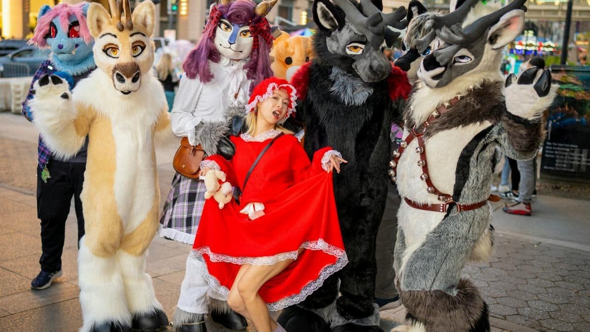 Vibrant costumed characters and a woman in festive attire pose in a San Jose town square.