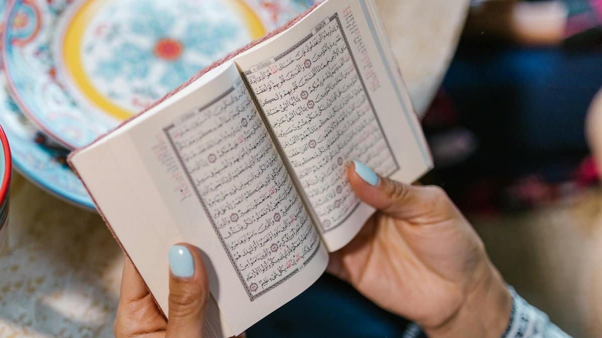 A woman engrossed in reading the Quran, signifying devotion and faith.