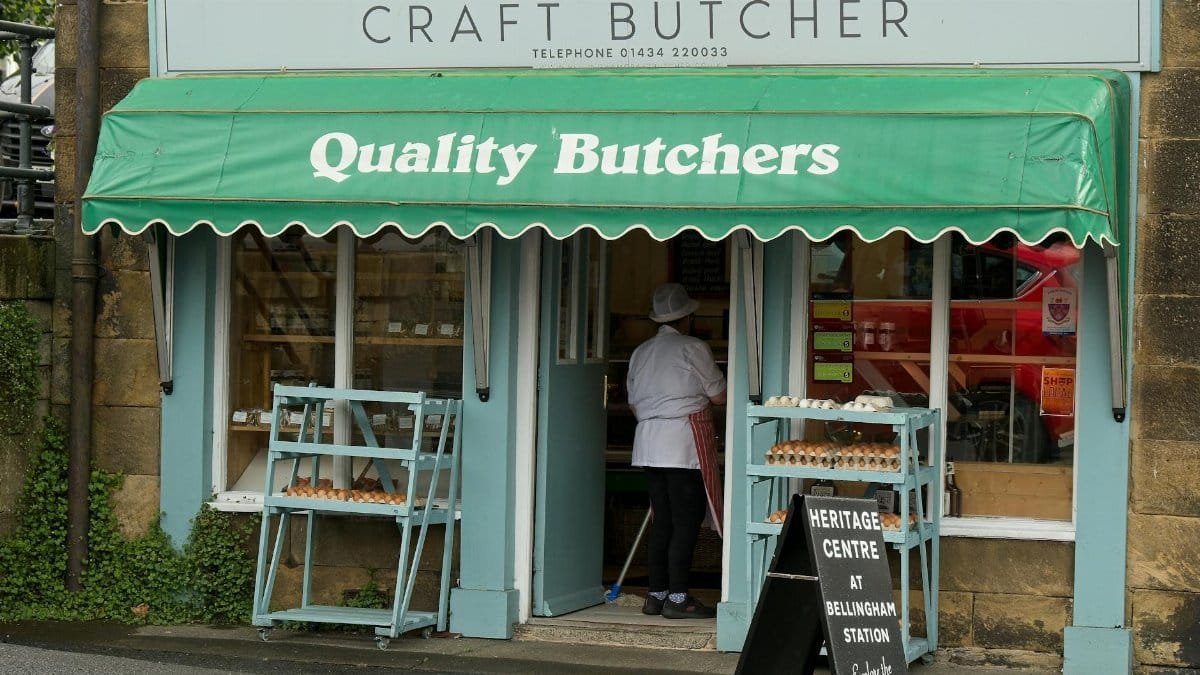 Exterior of a traditional butcher shop in Bellingham, UK, showcasing fresh meat and local produce.