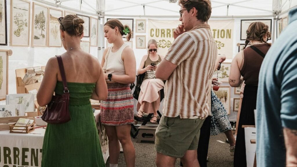 Visitors explore art displays at a bustling outdoor market in Chicago.