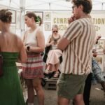 Visitors explore art displays at a bustling outdoor market in Chicago.