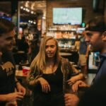 Group of friends enjoying a night out at a bar in Denver, sharing laughs and conversation.